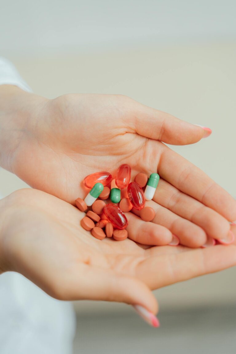 Close-up shot of hands holding assorted pills and capsules, emphasizing health and medication.